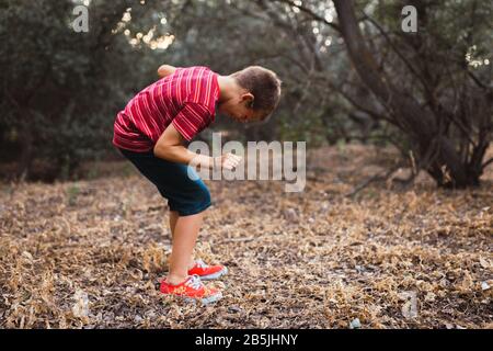 A boy dancing in the forest and smiling Stock Photo