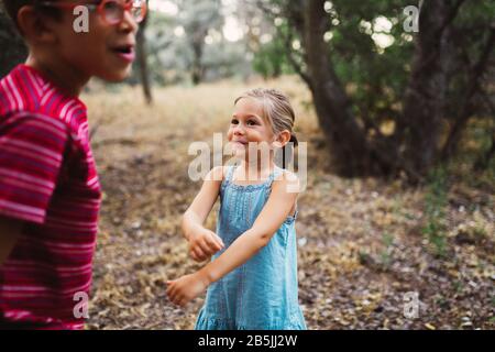 Two kids playing and dancing in the forest Stock Photo