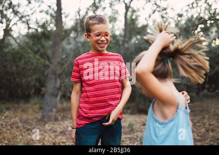 Two kids playing and dancing in the forest Stock Photo
