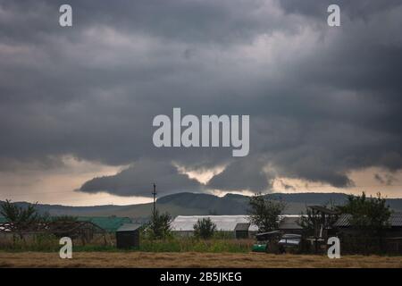 Dark threatening storm clouds over a hilly countryside Stock Photo