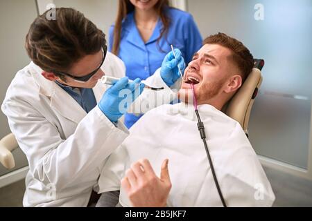Male patient at dentist having toothache Stock Photo