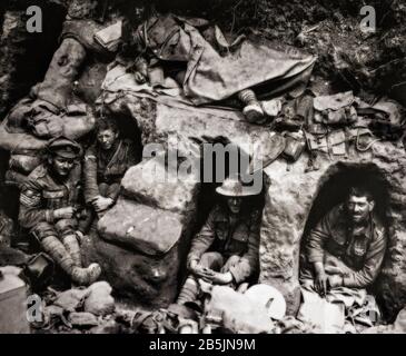 Soldiers of the Border Regiment taking a break in niches (or funk holes) built into the trenches near Thiepval Wood during the Battle of the Somme in August 1916. Stock Photo