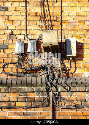 old wiring harness on a red brick wall Stock Photo