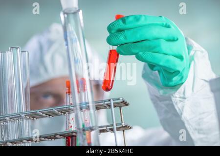 Virologist healthcare professional analyzing blood test sample in lab tubes, close up of medical worker working, selective focus Stock Photo