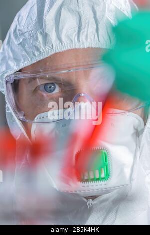 Virologist healthcare professional analyzing blood test sample in lab tubes, close up of medical worker working, selective focus Stock Photo