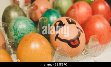 Colorful easter eggs. Face with tongue drawn on the egg. Stock Photo