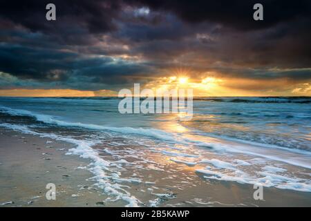 dramatic sunset over North sea waves Stock Photo