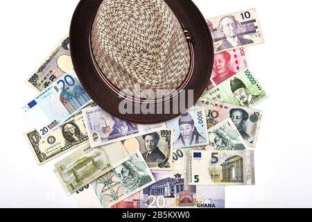 Travel around the world concept with straw hat and mixture of western and asian currencies Stock Photo