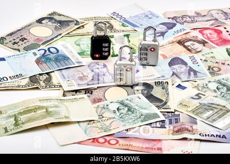 Travel safely around the world concept with padlocks and mixture of western and asian currencies Stock Photo