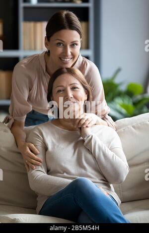 Portrait happy grownup daughter hugging pleasant mother. Stock Photo