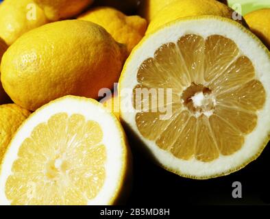 Close up image of freshly cut lemon and whole lemons Stock Photo