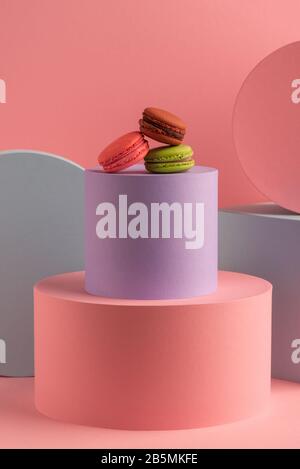 Various macarons on round boxes on pink background Stock Photo
