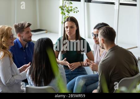 Diverse people sit in circle share ideas together Stock Photo