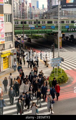 Commuters walking to work,Shinjuku,Tokyo, Japan with commuter train in background Stock Photo