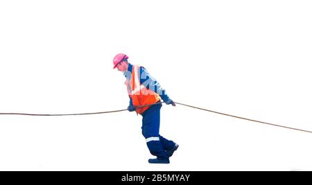 young worker in a signal vest and a helmet pulls the cable isolated on white background Stock Photo