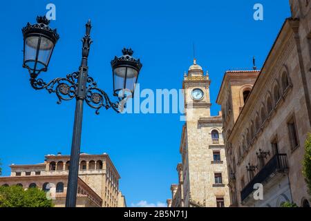 Beautiful street lamp and the clock tower of an antique building at Zamora Street in Salamanca city center