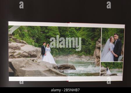 Kyiv, Ukraine- May 15, 2019 Pages of wedding photobook or wedding album on black background Stock Photo