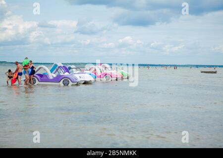 Svityaz- September 2019: colored old vintage plastic catamarans and boats near a wooden pier on the shore of a large lake Stock Photo