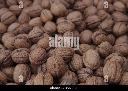 Close-up of a sack with many unpeeled nuts forms a natural wood-colored texture Stock Photo