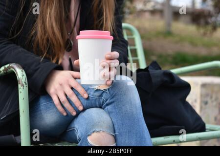 Female hand holding reusable coffee mug. Take your coffee to-go. Stock Photo