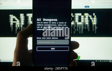 Montreal, Canada - March 08, 2020: AI Dungeon adventure text game on a cell phone over laptop screen. AI Dungeon is an open-source text adventure game Stock Photo