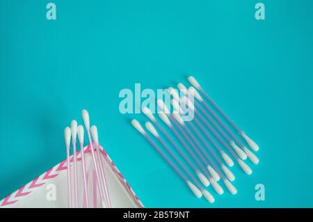 Top view, flat lay, a small group of pink plastic cotton swabs neatly arranged on a mint background, the concept of cleanliness and hygiene. Stock Photo
