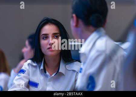 Technical Operator Works at His Workstation with Multiple Displays while talking on the phone, Security guards working on multiple monitors. Stock Photo