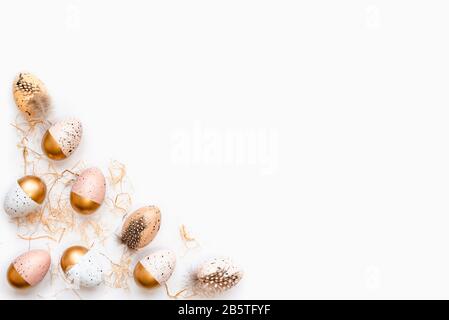 Top view of Easter eggs colored with golden paint. Various colorful designs. White background. Stock Photo