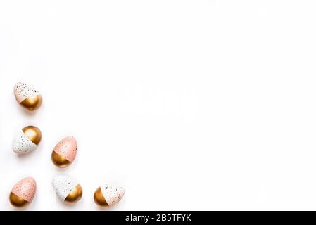 Top view of Easter eggs colored with golden paint. Various colorful designs. White background. Stock Photo