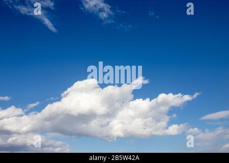White fluffy clouds on bright blue sky Stock Photo