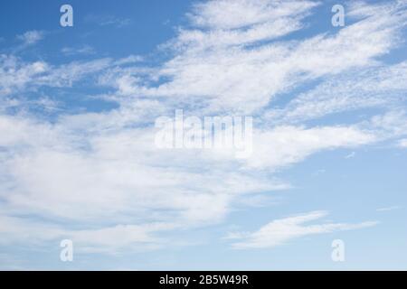 White fluffy clouds on bright blue sky Stock Photo