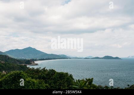 Scenic view of the South China Sea on the island, Vietnam. View through the jungle to the beautiful bay and mountains. Tropical beach. Stock Photo