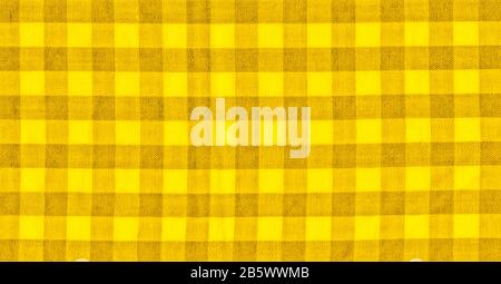 The texture of the bright yellow of binding gingham fabric. Yellow textile background. Fabric plaid. Close-up Stock Photo