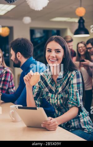 Happy woman drinking coffe while her friends, having fun on break and using tablet Stock Photo