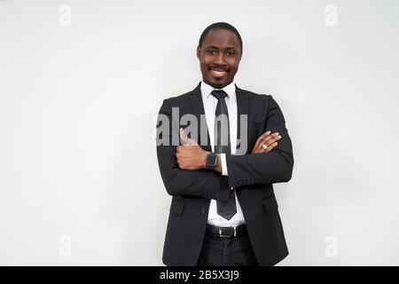 Smiling african businessman with thumbs up over grey background Stock Photo
