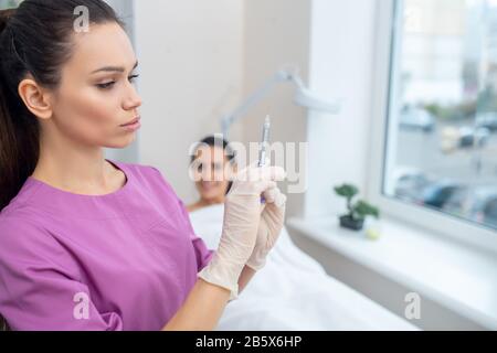 Cosmetologist taking syringe before making beauty injection Stock Photo