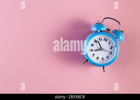 Blue vintage alarm clock on light pink color background. Alarm clock with place for text. Time management concept, business planning Stock Photo