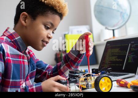 Male Elementary School Pupil Building Robot Car In Science Lesson Stock Photo