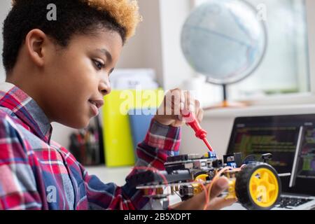 Male Elementary School Pupil Building Robot Car In Science Lesson Stock Photo