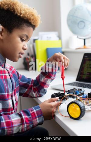 Male Elementary School Pupil Building Robot Car In Science Lesson Stock Photo