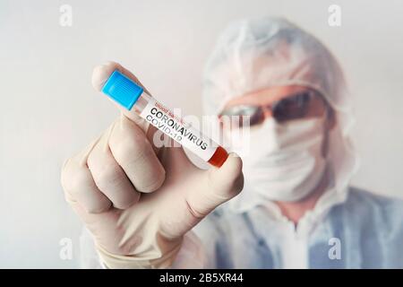 male medical, scientific researcher or doctor using sample tray to test blood sample in a laboratory. Development of antiviral drugs against the coron Stock Photo