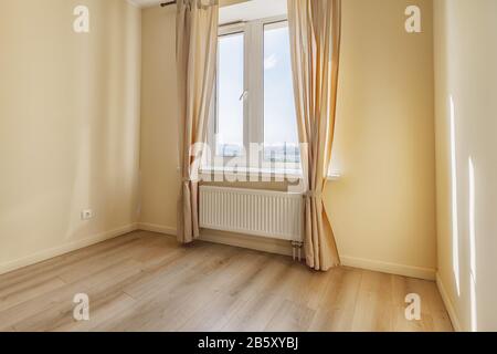 Open window with curtains in empty beige apartment sunny morning Stock Photo