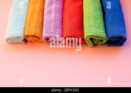 colorful microfiber towels, over pink background.Cleaning microfiber cloth isolated , Folded cleaning textile napkins colorful stack. Domestic Stock Photo