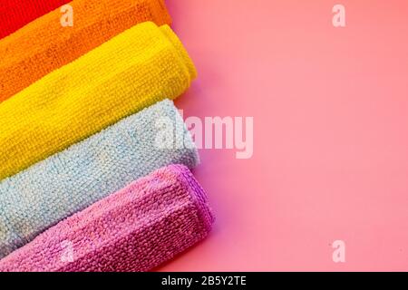 colorful microfiber towels, over pink background.Cleaning microfiber cloth isolated , Folded cleaning textile napkins colorful stack. Domestic Stock Photo