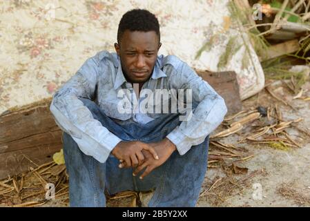 Sad young homeless African man in the streets Stock Photo