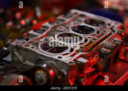 Horizontal high angle close up conceptual shot of car engine part with oil in red light, copy space Stock Photo