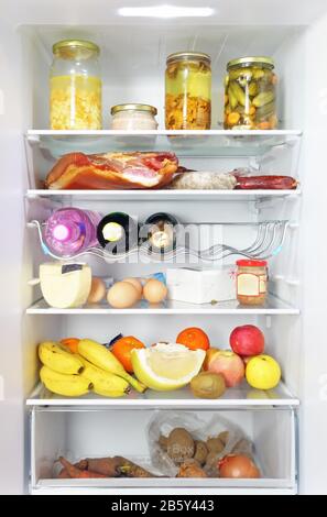 Fridge open full stocked  loaded up with food and fresh ingredients. Stock Photo