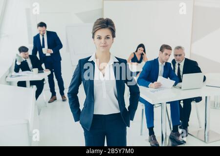 Young executive manager on the background of busy working staff Stock Photo