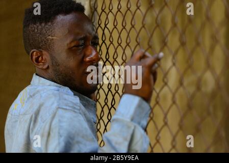 Face of young homeless African man looking depressed in the streets Stock Photo