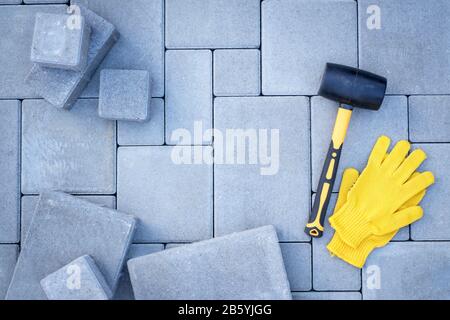 Paving stones paving background. Installing tools on foreground Stock Photo